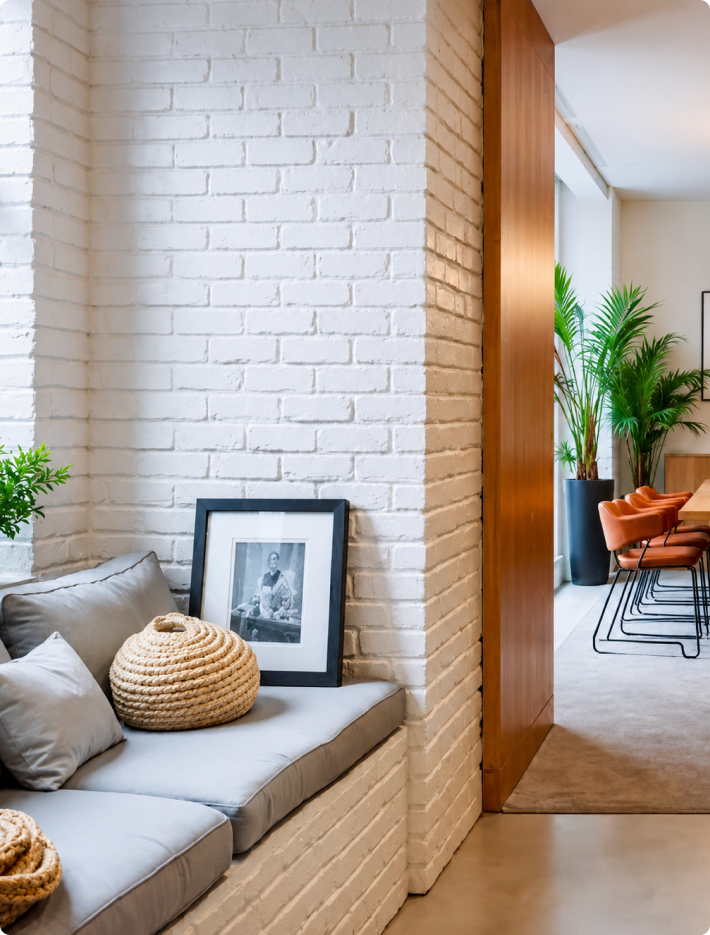 Bright living space with built-in window seat and painted brick wall