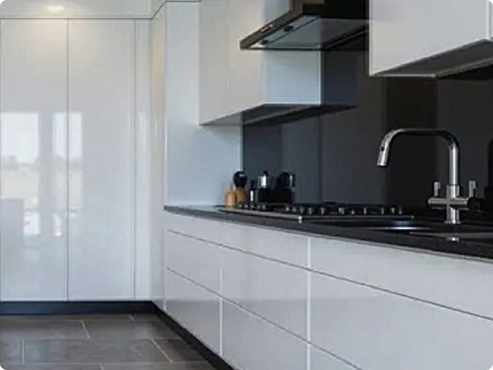 Modern white gloss kitchen with black splashback